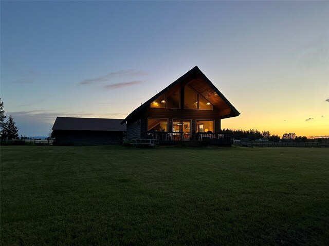 200 Weaver Ln, Kalispell, MT 59901 - back of house at dusk featuring a yard and a deck