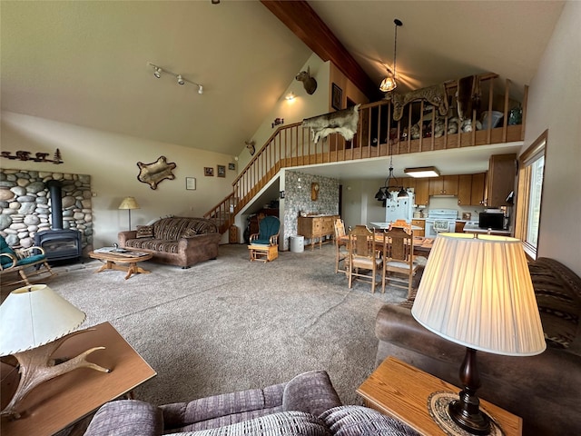 carpeted living room with high vaulted ceiling, a wood stove, stairs, and beam ceiling
