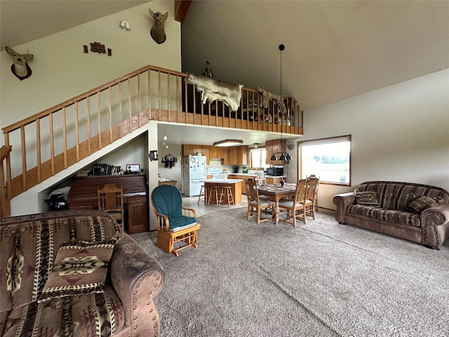 living room featuring high vaulted ceiling, carpet floors, and stairs
