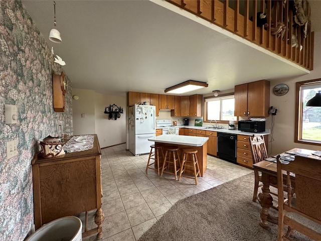 kitchen with black appliances, a sink, light countertops, brown cabinetry, and light tile patterned floors