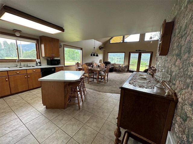 kitchen with black appliances, a sink, light countertops, brown cabinetry, and light tile patterned floors