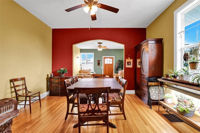 500 34th St NW, Great Falls, MT 59404 - dining area featuring a ceiling fan, arched walkways, light wood-style flooring, and baseboards