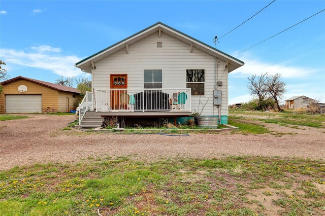 500 34th St NW, Great Falls, MT 59404 - view of front of property with an outdoor structure, a garage, a wooden deck, and dirt driveway