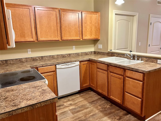 2905 Oshaughnesy St Unit 104, Missoula, MT 59808 - kitchen with white dishwasher, a sink, a peninsula, light wood-style flooring, and brown cabinets