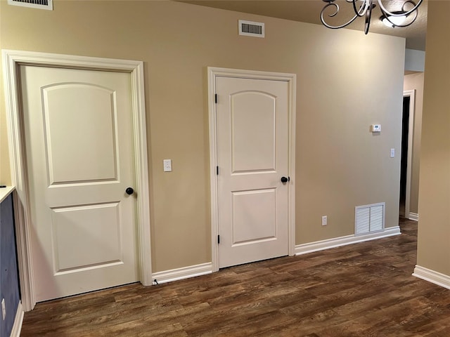 2905 Oshaughnesy St Unit 104, Missoula, MT 59808 - unfurnished bedroom with a chandelier, dark wood-type flooring, and baseboards