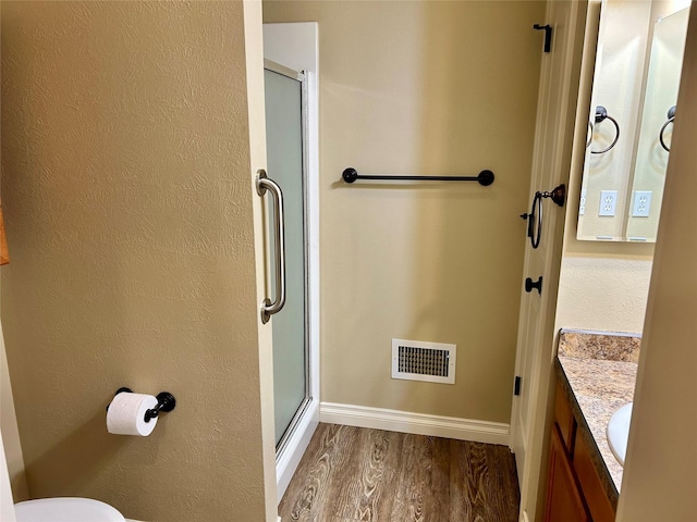 2905 Oshaughnesy St Unit 104, Missoula, MT 59808 - full bathroom featuring wood finished floors, a stall shower, vanity, baseboards, and toilet