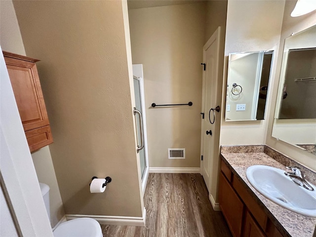 2905 Oshaughnesy St Unit 104, Missoula, MT 59808 - bathroom featuring wood finished floors, a shower stall, vanity, baseboards, and toilet
