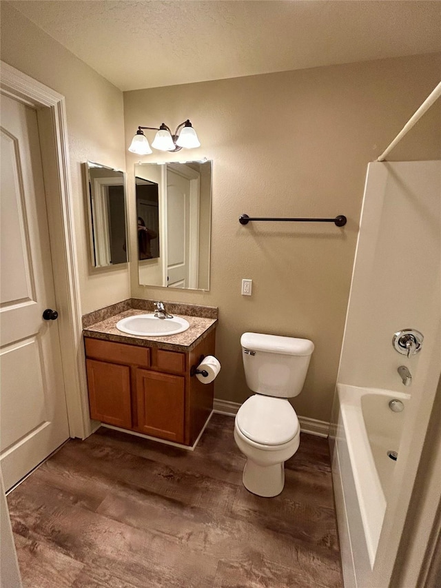 2905 Oshaughnesy St Unit 104, Missoula, MT 59808 - bathroom with vanity, tub / shower combination, a textured ceiling, and wood finished floors