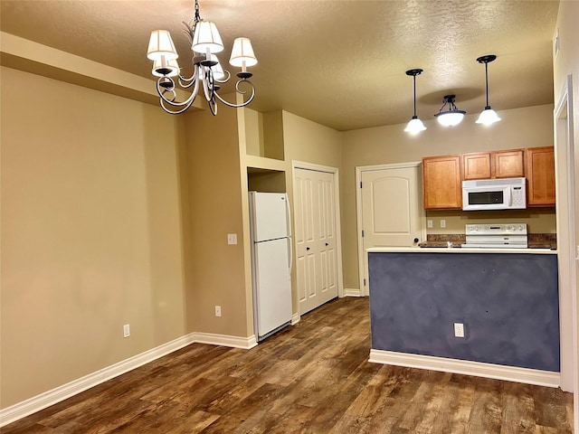 2905 Oshaughnesy St Unit 104, Missoula, MT 59808 - kitchen featuring white appliances, a chandelier, baseboards, a textured ceiling, and dark wood-style flooring