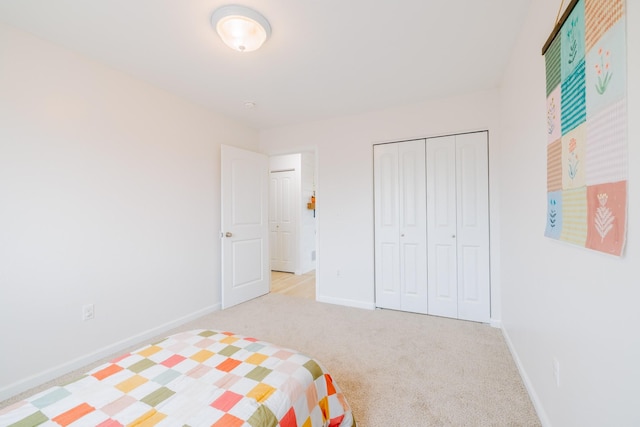 bedroom featuring baseboards, carpet, and a closet
