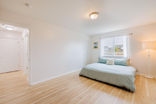 bedroom with baseboards and light wood-style floors