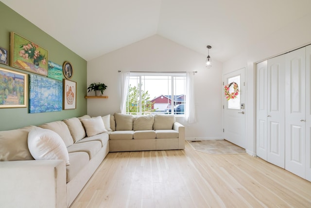 living area featuring light wood-type flooring and lofted ceiling