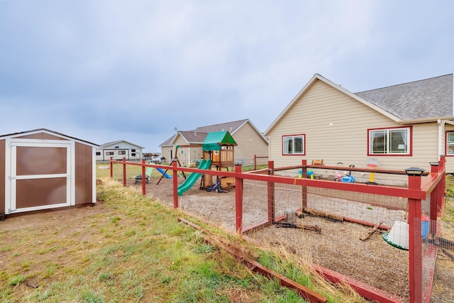 view of jungle gym with a shed, an outdoor structure, and fence