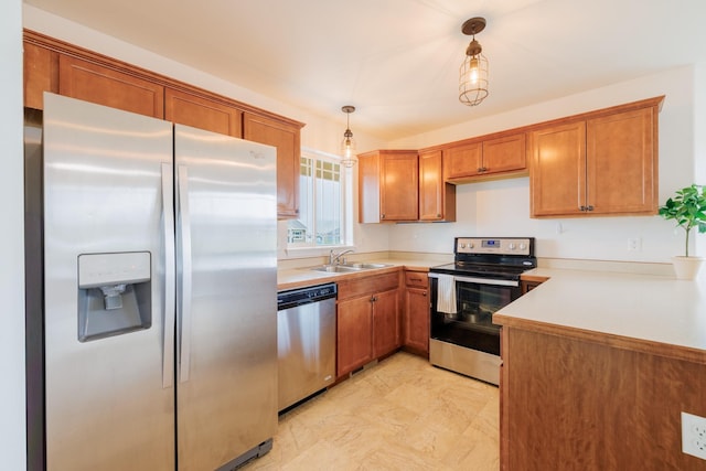 kitchen with appliances with stainless steel finishes, a sink, brown cabinetry, and light countertops
