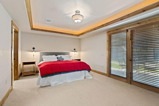 carpeted bedroom featuring a raised ceiling, baseboards, and access to outside