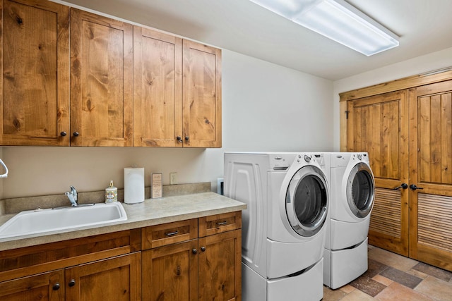 clothes washing area with cabinet space and washer and clothes dryer