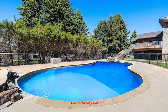 view of pool featuring stairs, fence, and a patio area