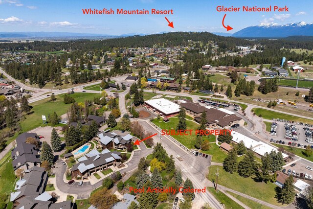view of property location featuring a heavily wooded area and nearby suburban area