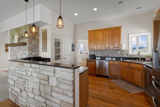 58 Morning View Way, Kalispell, MT 59901 - kitchen with stainless steel dishwasher, a sink, light wood finished floors, tasteful backsplash, and hanging light fixtures