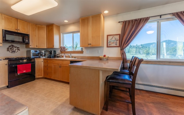 5550 Farm To Market Rd, Whitefish, MT 59937 - kitchen featuring black appliances, a peninsula, a sink, recessed lighting, and light brown cabinets