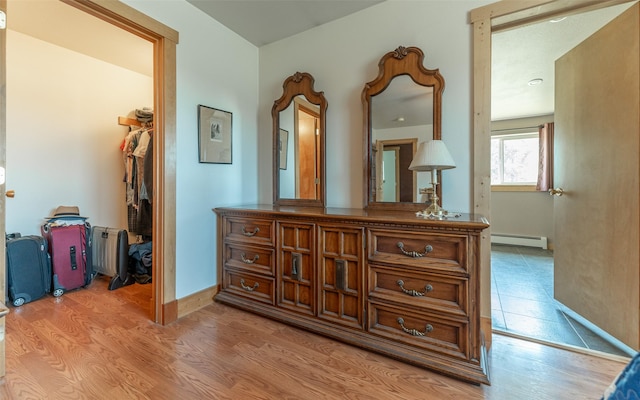 5550 Farm To Market Rd, Whitefish, MT 59937 - hallway with baseboard heating, light wood-style flooring, and baseboards