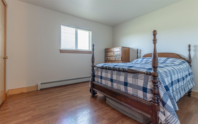 5550 Farm To Market Rd, Whitefish, MT 59937 - bedroom featuring a baseboard heating unit and wood finished floors