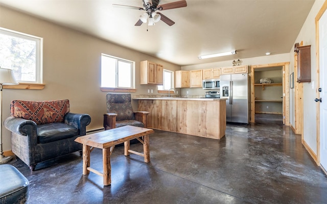 5550 Farm To Market Rd, Whitefish, MT 59937 - kitchen featuring appliances with stainless steel finishes, light brown cabinets, concrete floors, a peninsula, and a ceiling fan