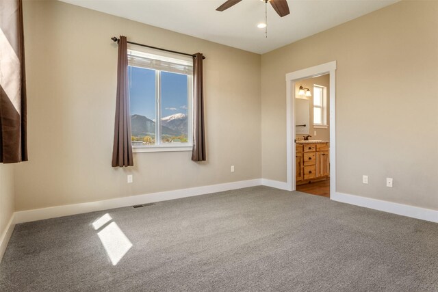 empty room featuring carpet flooring, ceiling fan, and baseboards