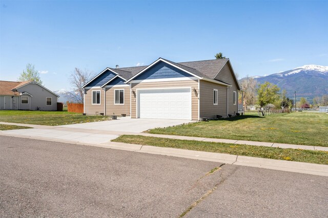 view of front facade featuring an attached garage, driveway, and a mountain view