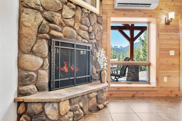 detailed view of an AC wall unit, wood walls, a mountain view, and a stone fireplace