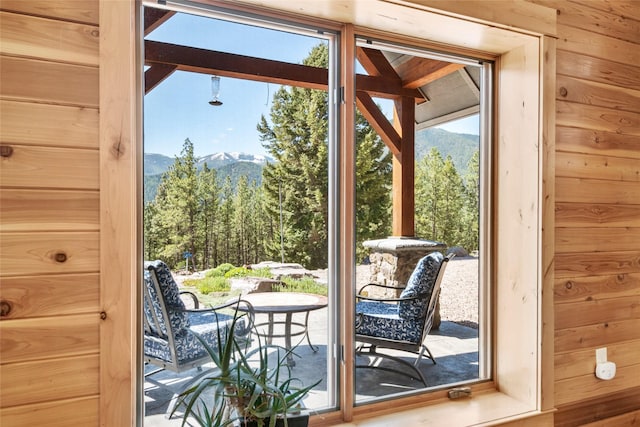 doorway with a mountain view and wooden walls