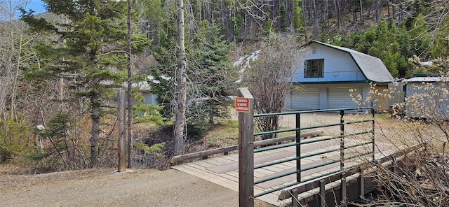 11169 Stemple Pass Rd, Lincoln, MT 59639 - view of outdoor structure with dirt driveway, a wooded view, and a garage