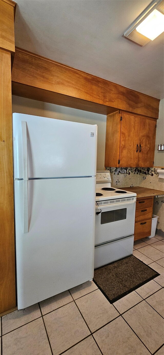 11169 Stemple Pass Rd, Lincoln, MT 59639 - kitchen with white appliances, brown cabinets, light tile patterned floors, and light countertops
