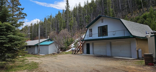11169 Stemple Pass Rd, Lincoln, MT 59639 - garage featuring dirt driveway and a view of trees