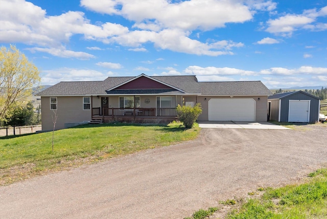 556 Fescue Slope Rd, Florence, MT 59833 - single story home featuring driveway, an attached garage, covered porch, an outdoor structure, and a shingled roof