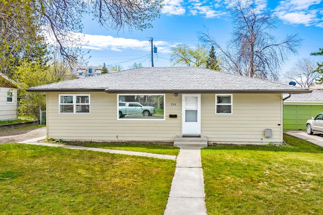 bungalow-style house with a front yard and roof with shingles