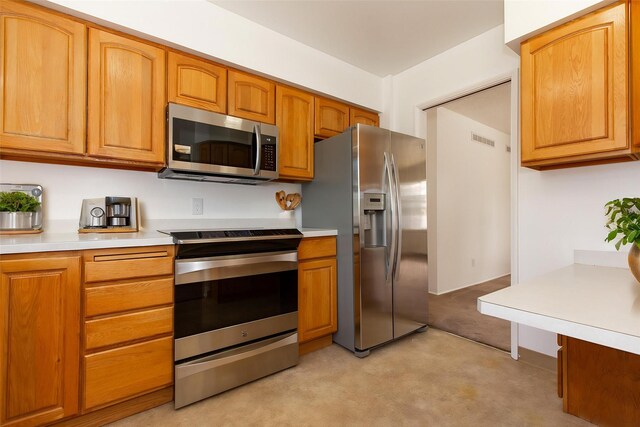 433 N 10th Ave, Bozeman, MT 59715 - kitchen featuring stainless steel appliances, light carpet, light countertops, and brown cabinetry