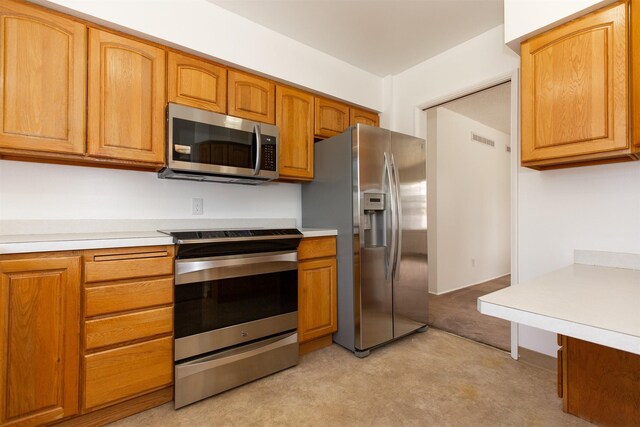 433 N 10th Ave, Bozeman, MT 59715 - kitchen with appliances with stainless steel finishes, light countertops, light carpet, and brown cabinetry