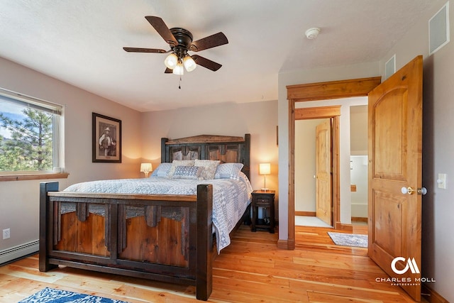 bedroom with a baseboard radiator, light wood-type flooring, ceiling fan, and baseboards