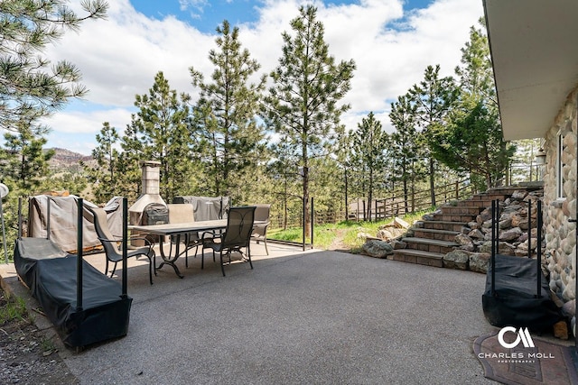 view of patio / terrace featuring outdoor dining space and stairs
