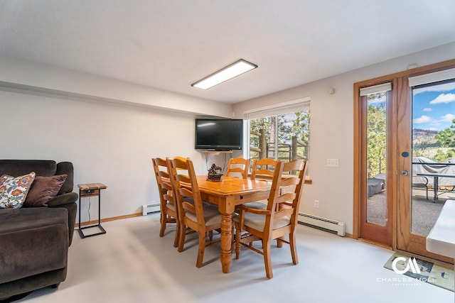 dining room with baseboard heating, light carpet, and baseboards