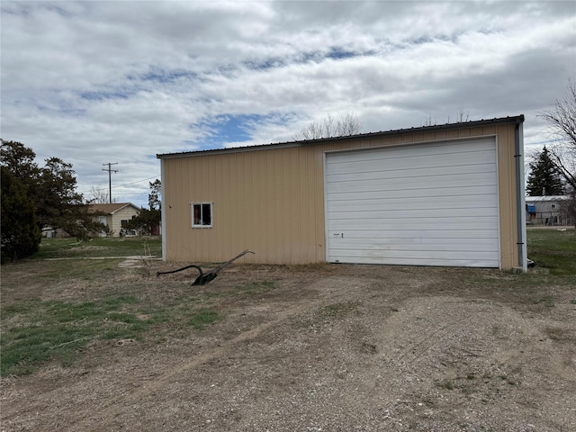 detached garage featuring dirt driveway