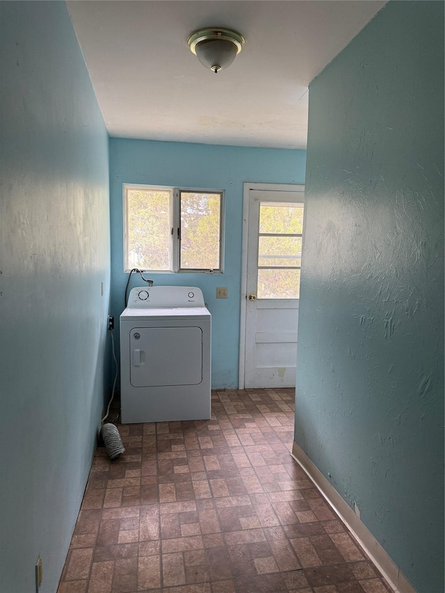 laundry area featuring washer / clothes dryer and brick patterned floors