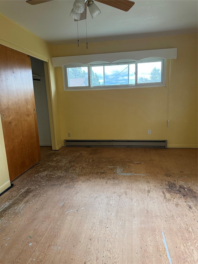 unfurnished bedroom with a baseboard heating unit, a closet, and ceiling fan