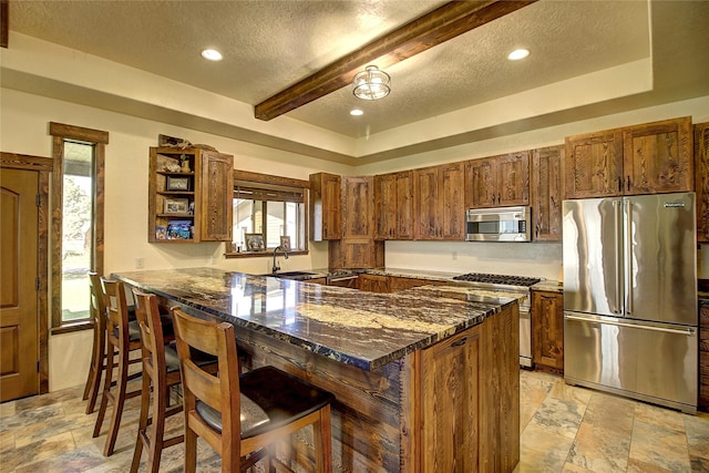 45292 Locust Ln, Charlo, MT 59824 - kitchen featuring high quality appliances, stone tile floors, a textured ceiling, a kitchen breakfast bar, and dark stone countertops