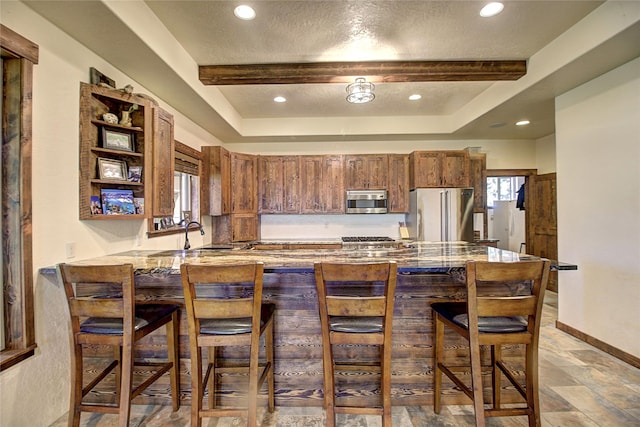45292 Locust Ln, Charlo, MT 59824 - kitchen featuring stainless steel appliances, a tray ceiling, a peninsula, a breakfast bar area, and recessed lighting
