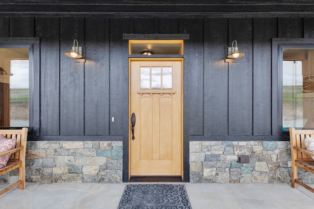 559 Stage Springs Ln, Stevensville, MT 59870 - view of exterior entry with board and batten siding, stone siding, and a porch