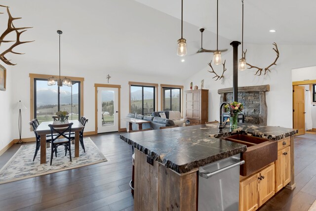 559 Stage Springs Ln, Stevensville, MT 59870 - kitchen featuring stainless steel dishwasher, dark countertops, dark wood finished floors, a sink, and vaulted ceiling