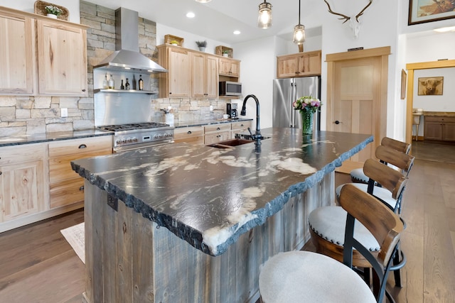 559 Stage Springs Ln, Stevensville, MT 59870 - kitchen featuring appliances with stainless steel finishes, wall chimney exhaust hood, a sink, light brown cabinetry, and dark wood finished floors