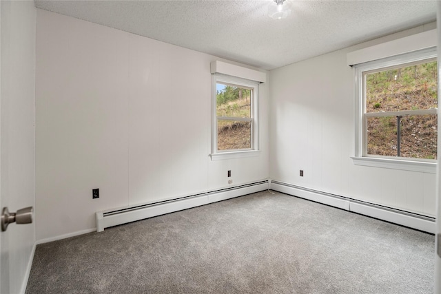 empty room with a textured ceiling, carpet floors, plenty of natural light, and a baseboard radiator
